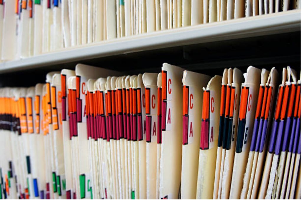 Alphabetized patient files representing PHI and an example of staying HIPAA-compliant